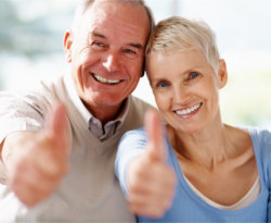 elderly couple thumbs-up pose with a smile
